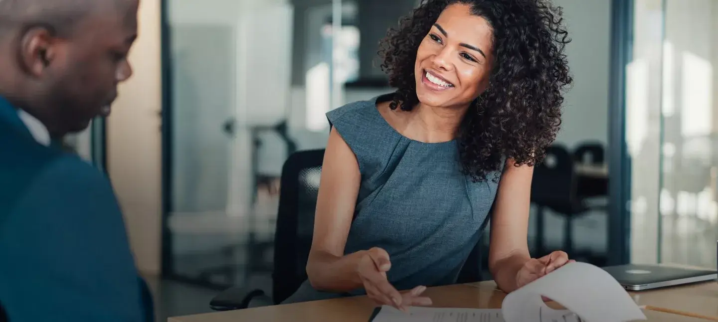 Young professional woman sharing resume with interviewer